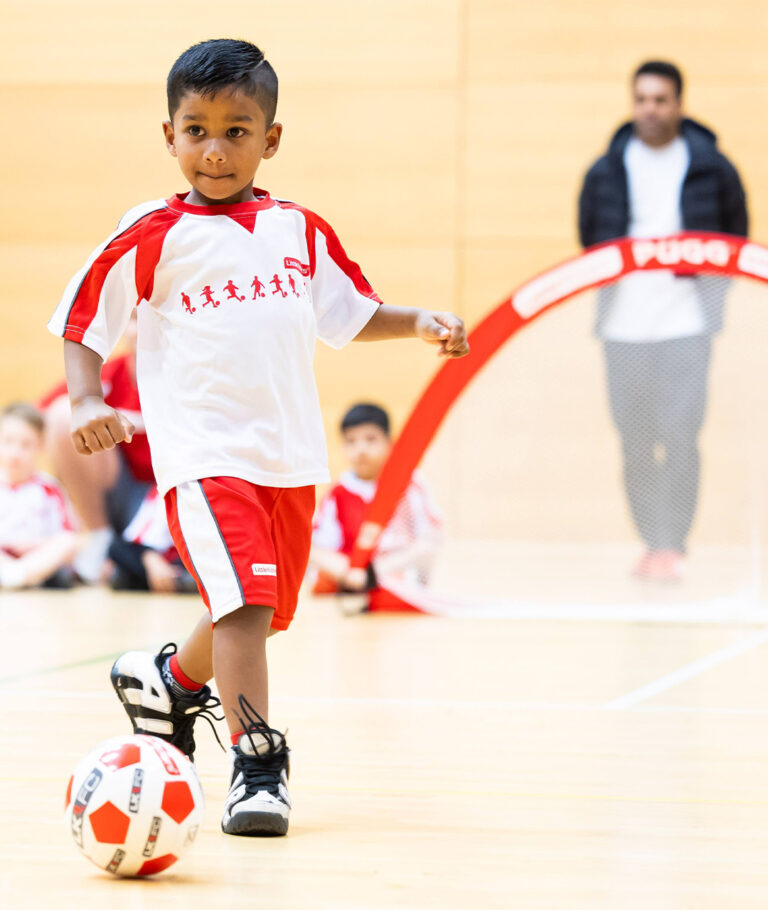 a child playing football with a ball